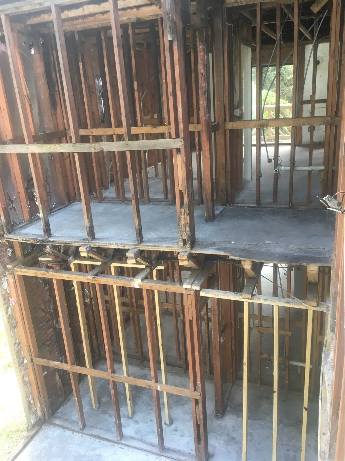 Fire-damaged house stripped back to the wood framing on both floors